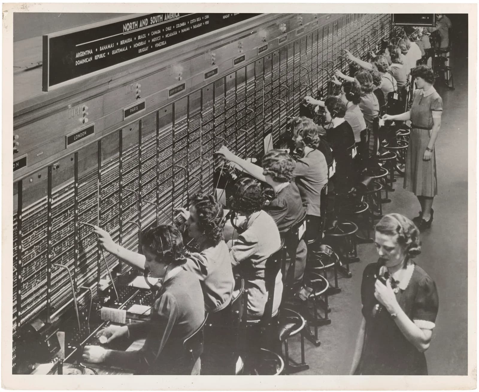 Women operators working at a Bell System telephone switchboard, connecting calls by hand.